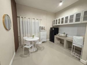 a small kitchen with a white table and chairs at 2 bedroom cute log house in Bacolod- near NGC in Bacolod +1 photo