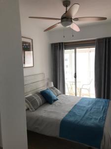 ein Schlafzimmer mit einem Bett mit Deckenventilator in der Unterkunft 150m2 Con vistas al Mar y al Castillo de Cullera in Cullera