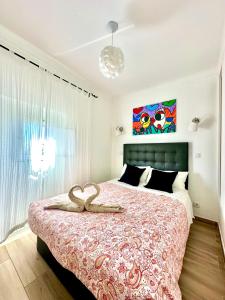 ein Schlafzimmer mit einem großen Bett mit einem Herz darauf in der Unterkunft Pirata Milfontes Guest House in Vila Nova de Milfontes