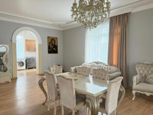 a dining room with a table and chairs and a chandelier at Petra Tsikhisdziri in Ts'ikhisdziri