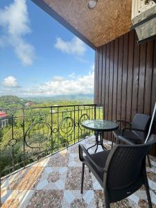 a balcony with chairs and a table and a view at Petra Tsikhisdziri in Ts'ikhisdziri
