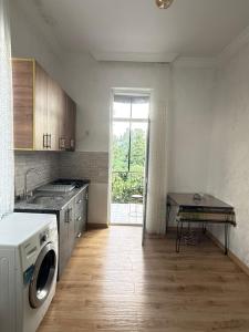 a kitchen with a washing machine and a table in it at Petra Tsikhisdziri in Ts'ikhisdziri