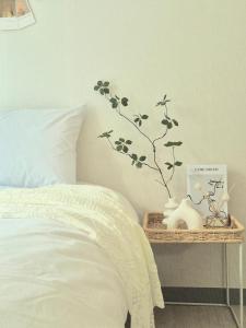 a bedroom with a bed and a branch on a table at Eumm stay in Cheongju