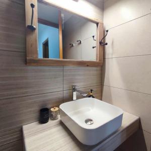 a bathroom with a white sink and a mirror at Limanaki in Kymi