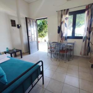 a bedroom with a bed and a table and chairs at Limanaki in Kymi