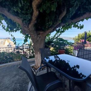a table and chairs in front of a tree at Limanaki in Kymi