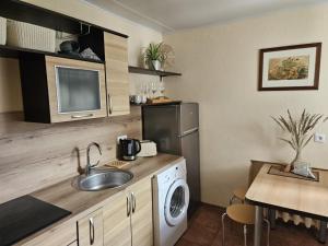 a kitchen with a sink and a washing machine at Nidos centras -Taikos g in Nida +4 photos