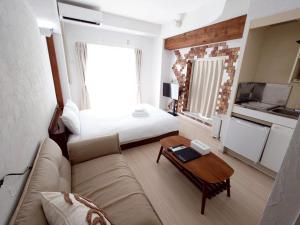 a living room with a couch and a bed at N's Hotel 平和公園 in Hiroshima