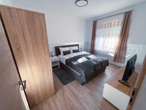 a bedroom with a bed and a television in it at L Apartment II in Maribor