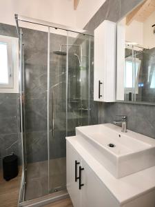 a bathroom with a white sink and a shower at Anna's Corfu Escape Apartments 2 in Corfu