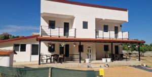a white house with balconies and a fence at The Brothers Villa in Ohrid