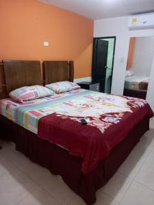 a bedroom with a bed with a blanket on it at Orempa Inn Hotel La Jagua in La Jagua de Ibirico