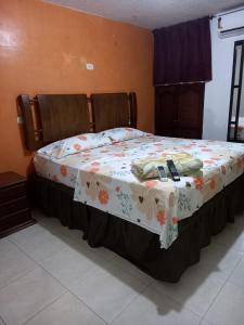 a bedroom with a bed with a blanket on it at Orempa Inn Hotel La Jagua in La Jagua de Ibirico