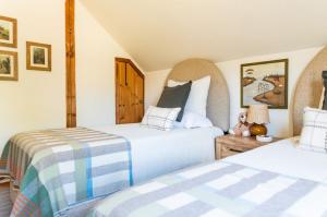 Un dormitorio con dos camas y una mesa. en New! Designer 3BR Cabin Walk to Pond Mtn Views, en Peru