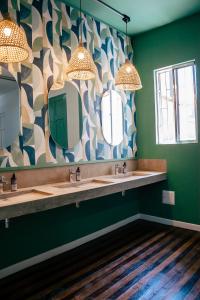 a bathroom with two sinks and two mirrors at Centro Hostel Medellin in Medellín +44 photos