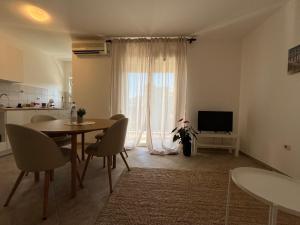 a living room with a table and chairs and a television at Galeb in Igalo +2 photos