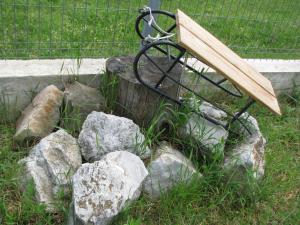 un banco sentado sobre rocas en la hierba en Pensiunea Neredy, en Baile 1 Mai