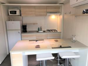 a small kitchen with a counter and a refrigerator at Mobilhome camping Rivage des Landes in Aureilhan