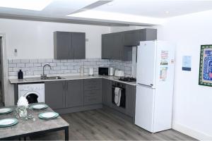 IfieldにあるThe Haven Ten -Trendy Escape -Free WiFi - Parkingの白い冷蔵庫とテーブルのあるキッチン