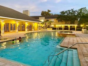 a swimming pool with two people in the water at Avalon, Clearwater in Clearwater +11 photos