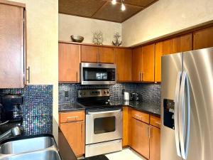 a kitchen with wooden cabinets and a stainless steel refrigerator at Avalon, Clearwater in Clearwater