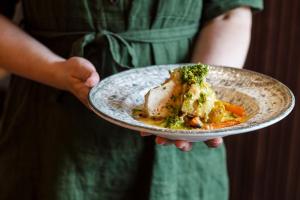 a person holding a plate of food on a plate at Hotell Sillen in Lysekil
