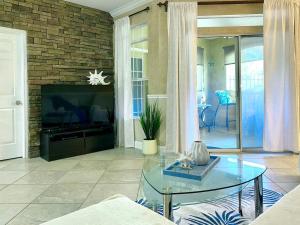 a living room with a glass table and a tv at Avalon, Clearwater in Clearwater