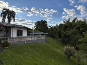 una casa en una colina con una valla y un patio en Finca Villa Monica- La Tebaida Quindío, en Estación El Salto