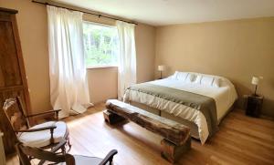 a bedroom with a bed with a bench and a window at Refugio de Glaciares in El Chalten