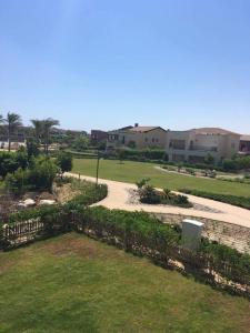 a walkway through a park with buildings and grass at Townhouse for rent in marassi isola 0 in El Alamein +16 photos