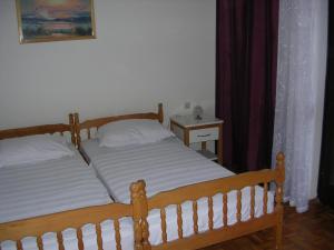 a bedroom with two beds and a table with a night stand at Apartment Perkovic Jadranka in Kornić +25 photos