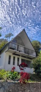 a white house with a balcony and red flowers at Termales el Ocho Villa Santa Helena in Zetaquira
