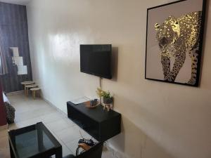 a living room with a picture of a leopard on the wall at chic studio - 10 minutes du plateau in Abidjan