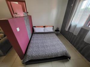 a bed in a room with a purple cabinet at chic studio - 10 minutes du plateau in Abidjan