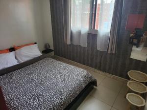 a small bedroom with a bed and a window at chic studio - 10 minutes du plateau in Abidjan