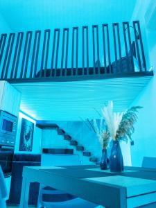 a blue room with a table and a staircase at VaKKia - Ortigia Holiday Home in Siracusa