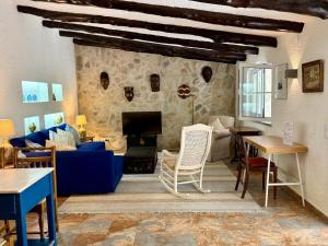 - un salon avec un canapé bleu et un mur en pierre dans l'établissement Charming cottage, pool & garden by Guincho beach, à Aldeia de Juso