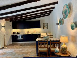 une cuisine et un salon avec une table et des chaises dans l'établissement Charming cottage, pool & garden by Guincho beach, à Aldeia de Juso