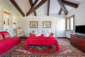a living room with a red bed and a tv at Vip Venice Apartments and Rooms San Marco 5134 e 274 in Venice