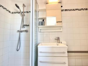 a white bathroom with a sink and a shower at Studio des brises centre-ville in Lorient