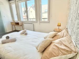 a bedroom with a large white bed with a window at Studio des brises centre-ville in Lorient
