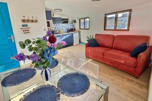 a living room with a red couch and a glass table at Charmant duplex Béziers les Halles in Béziers