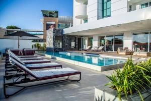 a swimming pool with chaise lounge chairs next to a building at Mercure Uberlândia Plaza Shopping in Uberlândia