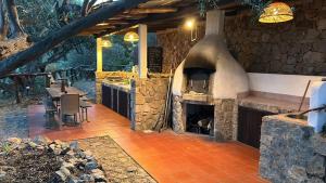 a large stone fireplace in a restaurant with a table at Eolian Villa Mare - Floating over the sea in San Salvatore