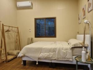 un dormitorio con una cama y una ventana en Hidden Gem Cozy House, en Wok Tum