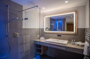 un bagno con lavandino e doccia in vetro di Sonnenhof Genusshotel & Appartements a Pertisau Altre 37 foto