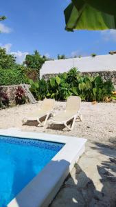 two chairs sitting next to a swimming pool at Unique and quiet TROPICKÝ PRÁZDNINOVÝ DŮM in Punta Cana