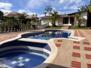 una piscina en un patio con una casa en Finca Villa Monica- La Tebaida Quindío, en Estación El Salto