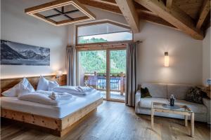 una camera da letto con un letto grande e un divano di Sonnenhof Genusshotel & Appartements a Pertisau