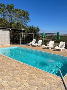 a swimming pool with lounge chairs at Quintal De Minas in Delfinópolis